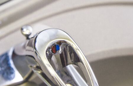 Top close-up , close up photo of steel metal water tap valve control handle in a bathroom . Old used...
