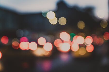 Street bokeh blur urban night evening lights, cars headlights headlamps on european streets. Traffic jam in town with fast motion vehicles.の写真素材