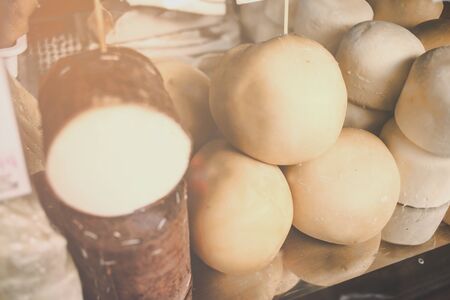 White and smoked scamorza in the basket, Italian typical cheese collection on the vitrine of market . French , Scamorze and cottage cheese .Dairy products and vegetables. Grocery shop. Food themeの写真素材