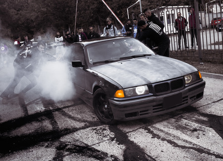 Moldova 25.09.2019. Sport modern Stance Car racing car drifting with smoke drift burnout, big colourful green blue clouds with clean wheels and burning tires . Extreme street stunts.のeditorial素材