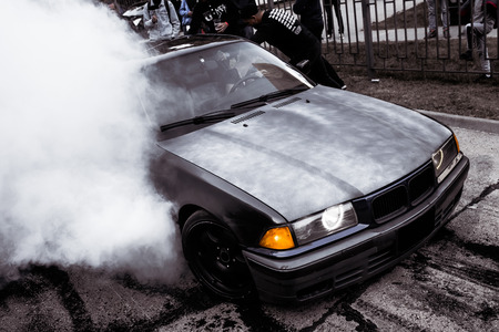 Moldova 25.09.2019. Sport modern Stance Car racing car drifting with smoke drift burnout, big colourful green blue clouds with clean wheels and burning tires . Extreme street stunts.のeditorial素材