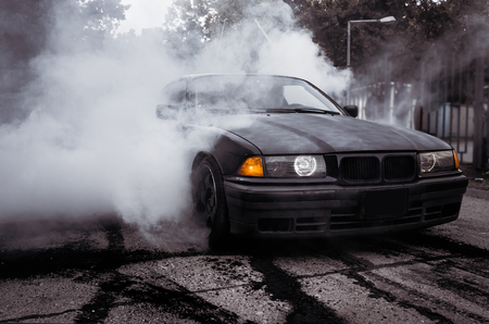 Moldova 25.09.2019. Sport modern Stance Car racing car drifting with smoke drift burnout, big colourful green blue clouds with clean wheels and burning tires . Extreme street stunts.のeditorial素材