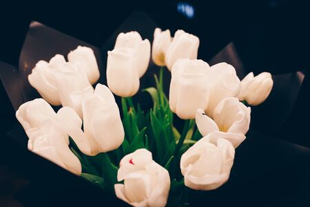 bunch of white tulips bouquet at dining restaurant. Soft focus tulip, top view displayed , luxury jewelry love gift on Valentines Day and romantic holidaysの写真素材