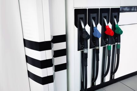 Pumping  red green blue black Guns for refueling at a gas oil diesel station on a sunset day . Car...