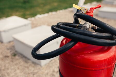 Fire close-up extinguishers available in fire emergencies at a petrol station background.
