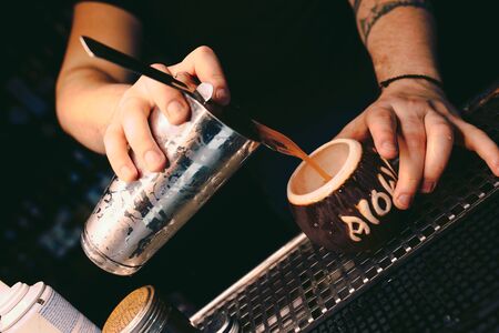 Bartender pouring using strainer White healthy Cocktail drink on a bar counter . Professional view ....