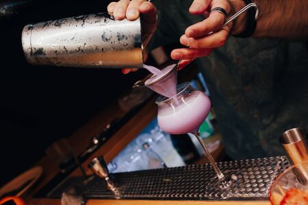 Bartender pouring using strainer White healthy Cocktail drink on a bar counter . Professional view . Trendy stylish alcoholic drink .  Design people and luxury concept service barman in nightclubの写真素材