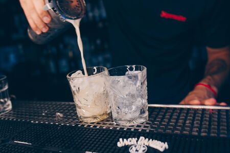 Bartender pouring using strainer White healthy Cocktail drink on a bar counter . Professional view ....