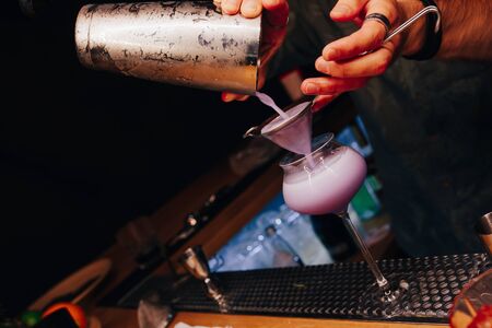 Bartender pouring using strainer White healthy Cocktail drink on a bar counter . Professional view . Trendy stylish alcoholic drink .  Design people and luxury concept service barman in nightclubの写真素材
