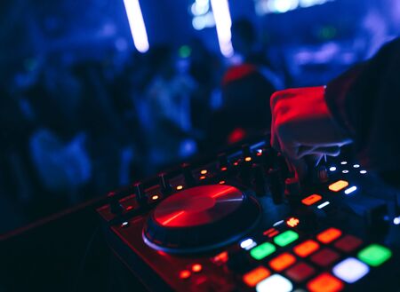producer  DJ mixer in a nightclub with glowing plays musical rave Dubstep Electronic Trance composition with modern midi controller device in nightclub Live.Musical production process for artists.の写真素材