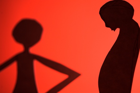 man and woman silhouette cut in small rudimentary figures  in paper , shot with colorfull backgroundの写真素材