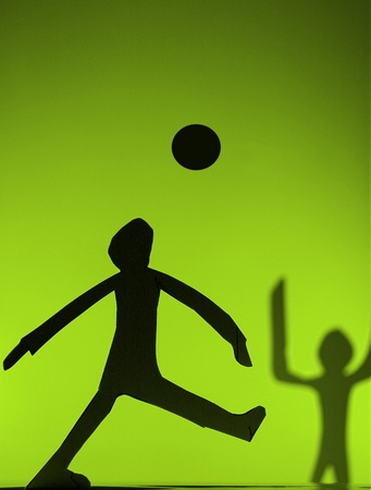 people silhouette cut in small rudimentary figures  in paper , shot with colorfull backgroundの写真素材