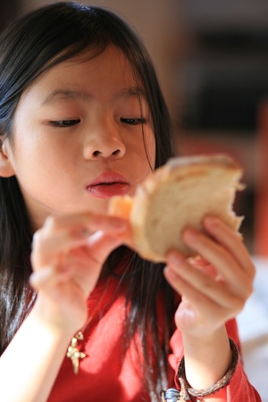  close up of hungry child eating breadの写真素材