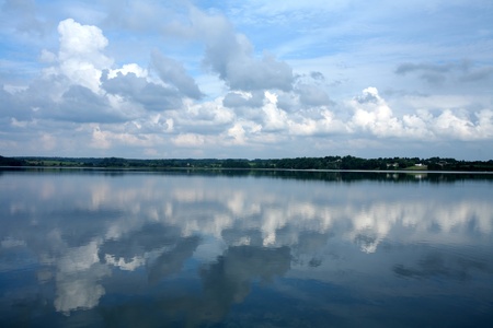 Reflection in a lake in denmark with blue cloudy skyの写真素材