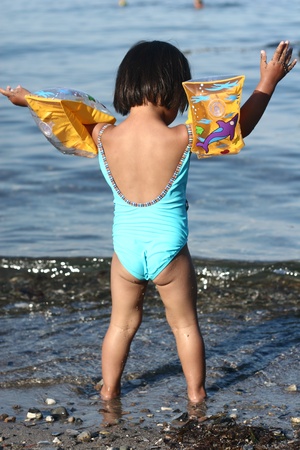 child  having fun with water  a summer day at the beachの写真素材