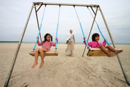 Family with two girls at the beach on a seesawの写真素材