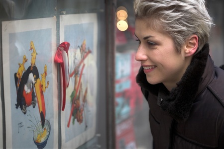 woman outdoor in a city on shopping tour, looking into a shop window