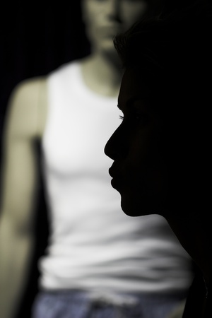  nightlife : woman outdoor in a  city  on shopping tour,  profile of her passing by a shop with man modelの写真素材