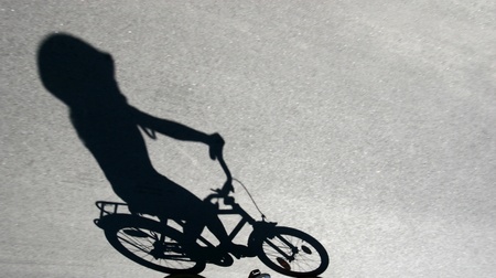 shade on the road of a child on  a bicycle 
の写真素材