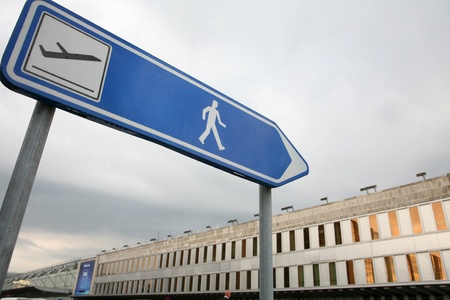 airplane departure sign  in brussels with airport in the backgroundの写真素材