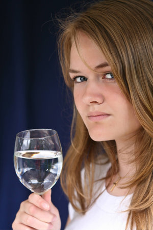 Girl with a glass of water looking at the cameraの写真素材