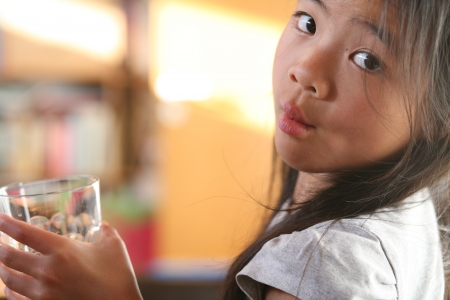 child drinking a glass of water on white backgroundの写真素材