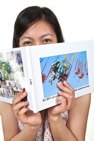 Portrait of a cute young  asian girl in studio reading a bookの写真素材