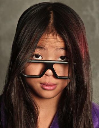 Cute asian small girl in kimono looking at the cameraの写真素材
