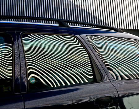 Car and stripes, car parked in front of a building with striped pattern