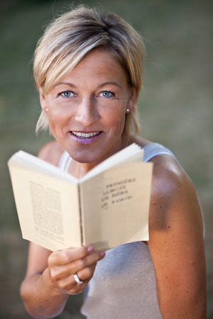 Cute woman reading a book outdoorの写真素材