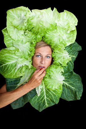 Cute woman with salad leaves arranged around her head.  Can be used for healthy food conceptの写真素材