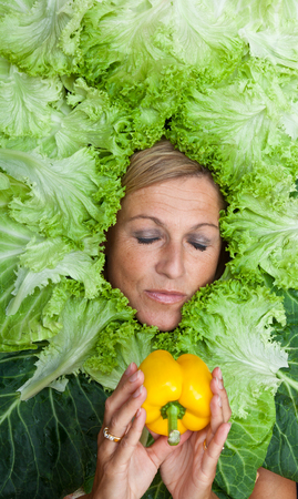 Cute woman with salad leaves arranged around her head.  Can be used for healthy food conceptの写真素材