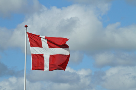 Danish flag against a blue but cloudy skyの写真素材