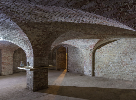 Cellar room made of brick with curved ceiling and an entrance with a  shaft of light beaming in.のeditorial素材