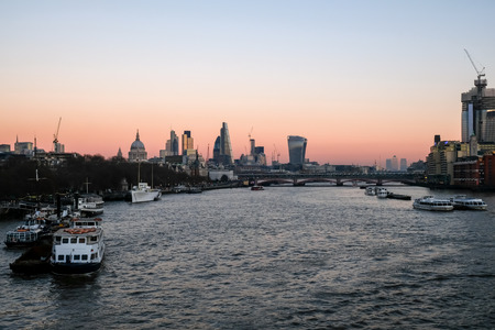 London skyline. Dusk shot of the river  Thames and the skyscrapper buildings in the City and to the East of the City at Canary Wharf.の写真素材