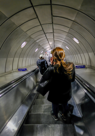 London, UK - May 5, 2017:  Passengers going down the escalator on the London underground.のeditorial素材