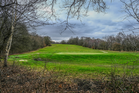 Landscape view of a golf course with a flag at the hole.の写真素材