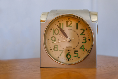 Antique alarm clock on a plain background.  Luminous numbers and classic style.