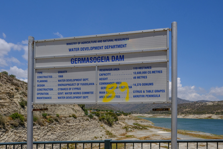 Germasogeia, Cyprus - June 18, 2018: Sign for Germasogeia Dam prominent in the shot with the water and hills in the background.のeditorial素材