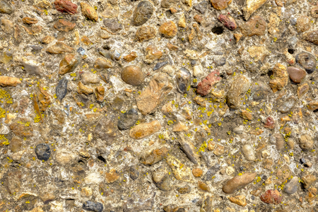 Background shot of stone wall which is weathered and has yellow lichen growing.の写真素材