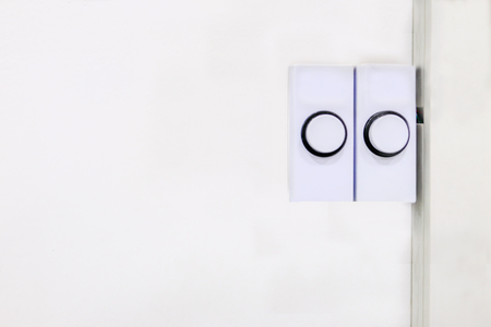Two white plastic rectangular door bell buttons ready for pushing to alert the occupant that someone...