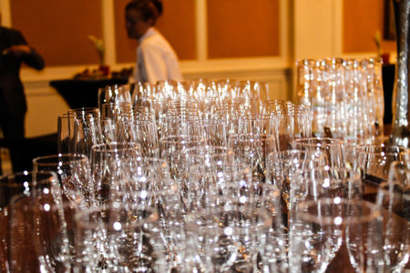 A collection of sparkling glassware arranged on a table, with a blurred background. The glasses reflect light beautifully, creating a festive atmosphere.の写真素材