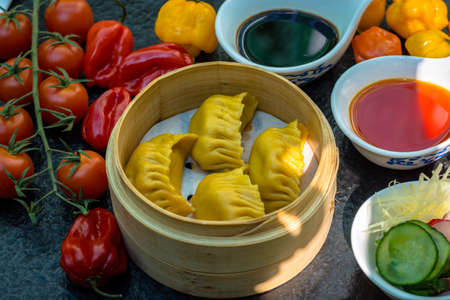 Yellow coloured beautiful dumpling with vegetables and sauceの写真素材