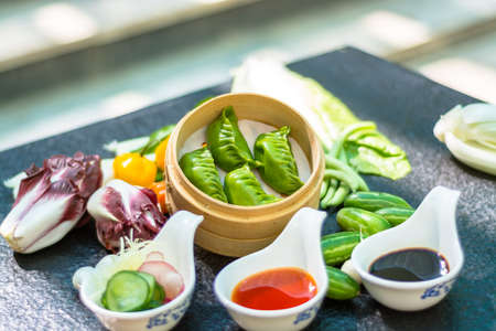 Green dumpling with sauceの写真素材