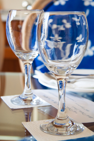Empty wine glasses on a table with a noteの写真素材