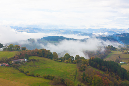 Green hills and mountains in the fog in Tineo, Asturias, Spainの写真素材