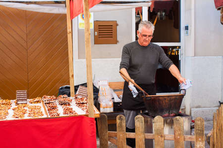 Porreres, Mallorca, Spain - October 27, 2019: Man cooking almond nougat for sale on Porreres Market. Majorca, Spainのeditorial素材