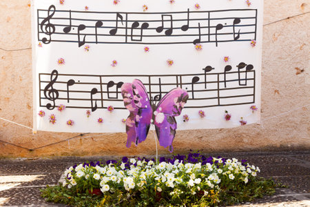 Decoration with a butterfly over a flowerbed with some musical notes in the background on "Costitx en Flor" (Costitx in bloom) Flower Fair, Majorca, Spainの写真素材