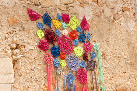 Decoration, consisting of colorful crochet dreamcatchers on the stone wall, on "Costitx en Flor" (Costitx in bloom) Flower Fair, Majorca, Spainの写真素材