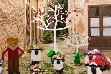 Composition of a shepherd and his sheep, decorated with flowers, on "Costitx en Flor" (Costitx in bloom) Flower Fair, Majorca, Spainの写真素材